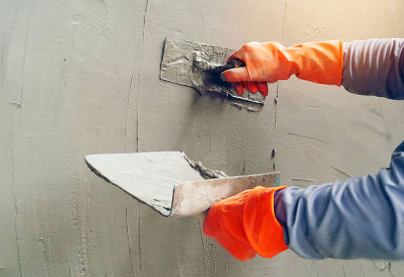 Skilled plasterer Dandenong applying smooth plaster on an interior wall